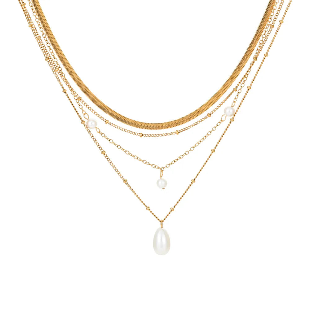 Studio shot of an 18K gold plated multi-layer necklace featuring a herringbone chain and pearl pendants, isolated on white