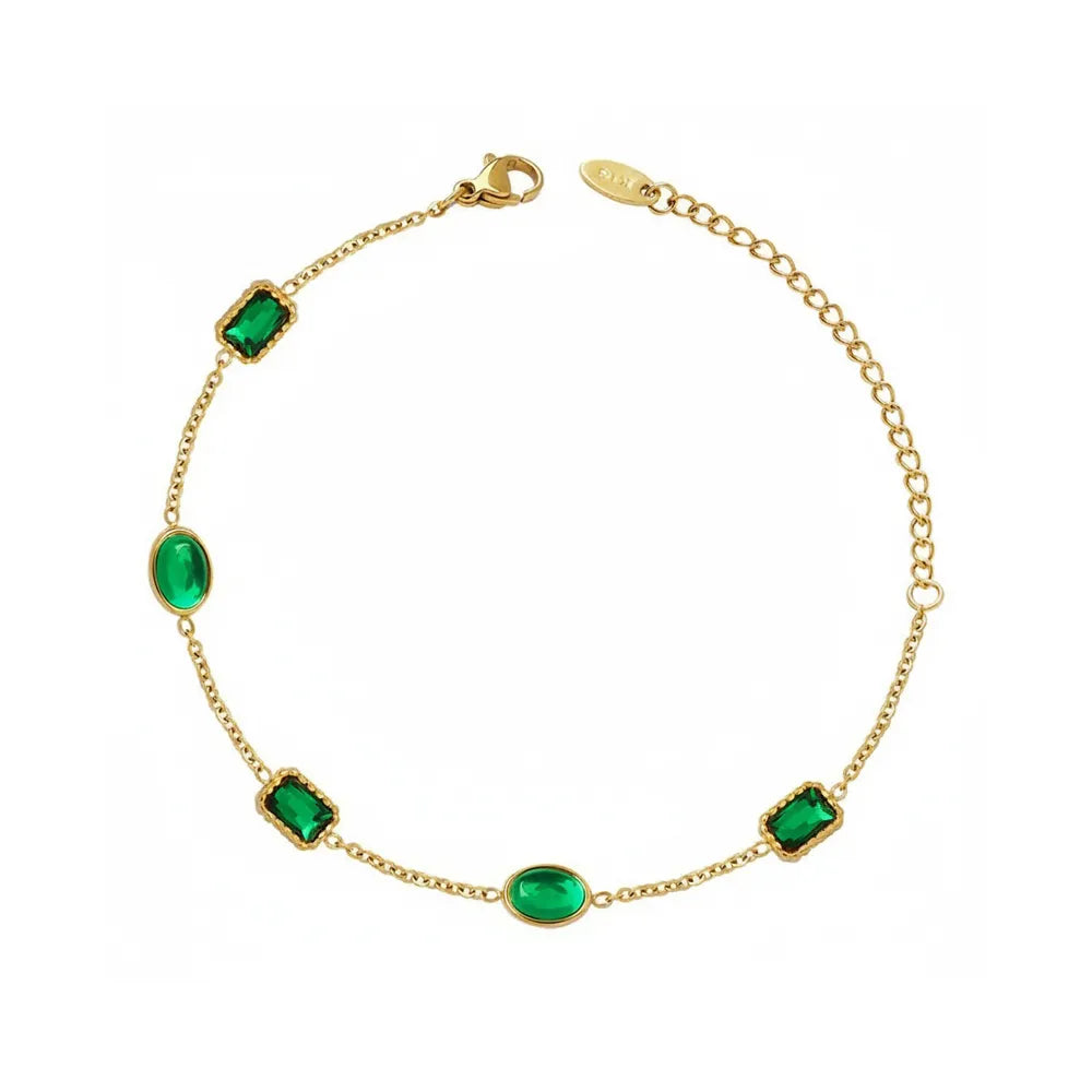 Studio shot of an 18K gold plated bracelet featuring alternating rectangular and oval emerald green zircon stones, isolated on white