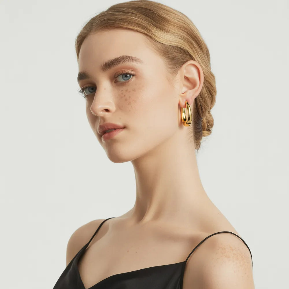 Model wearing the bold, 18k gold Anya Sculptural Hoop Earrings.