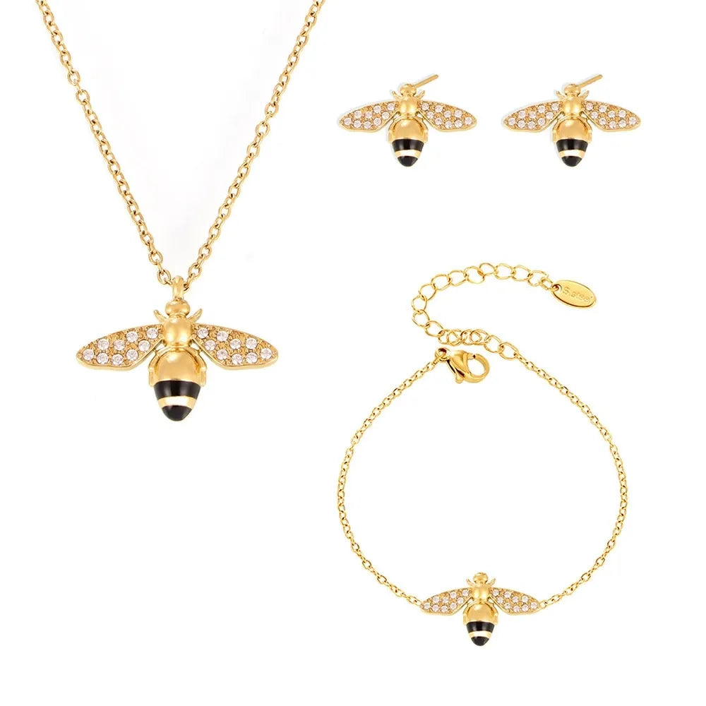 The complete Apia Pavé Bee Charm Jewelry Set in 18k gold, including necklace, bracelet, and stud earrings.