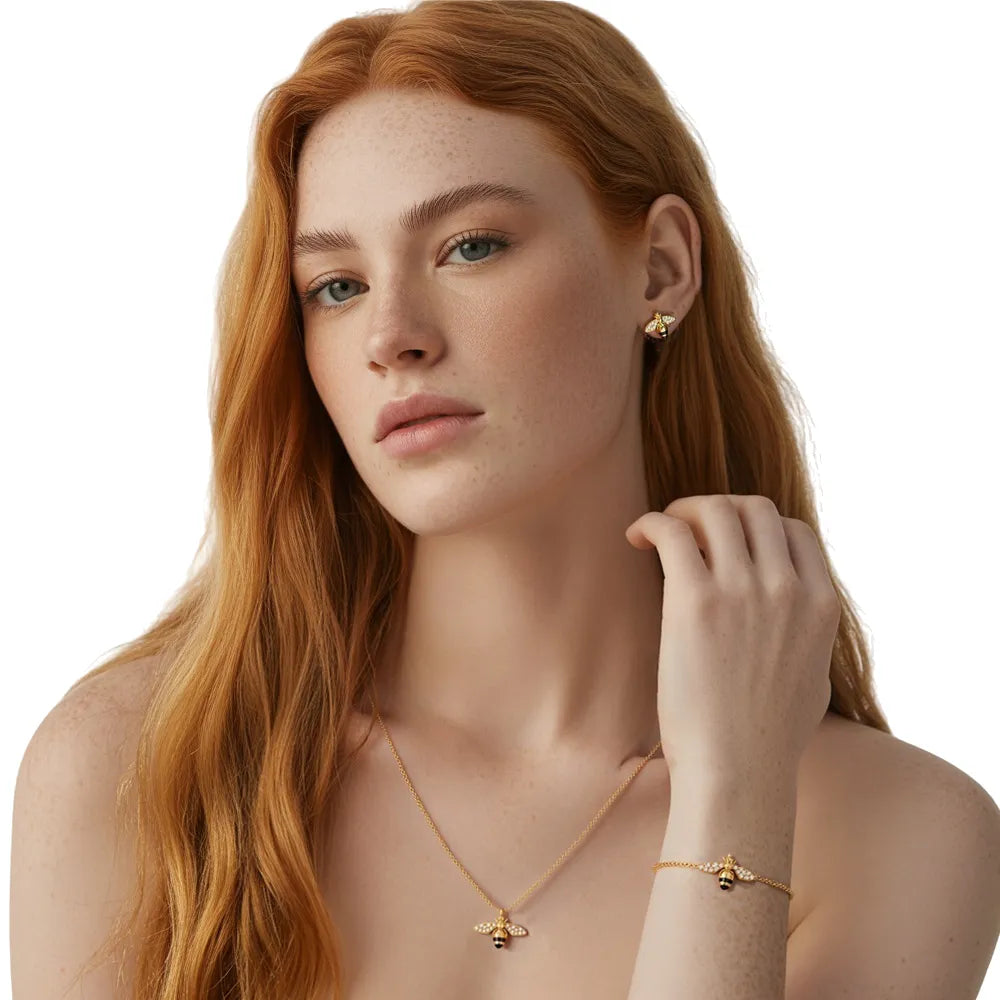 Close-up on a model wearing the sparkling gold pavé bee necklace, bracelet, and studs.