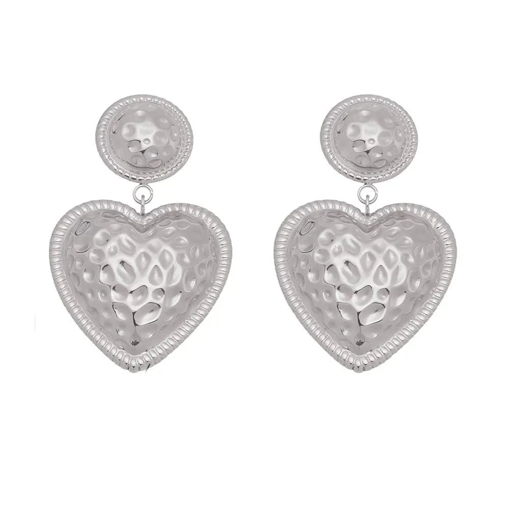 Polished 316L stainless steel drop earrings with textured baroque heart charms.