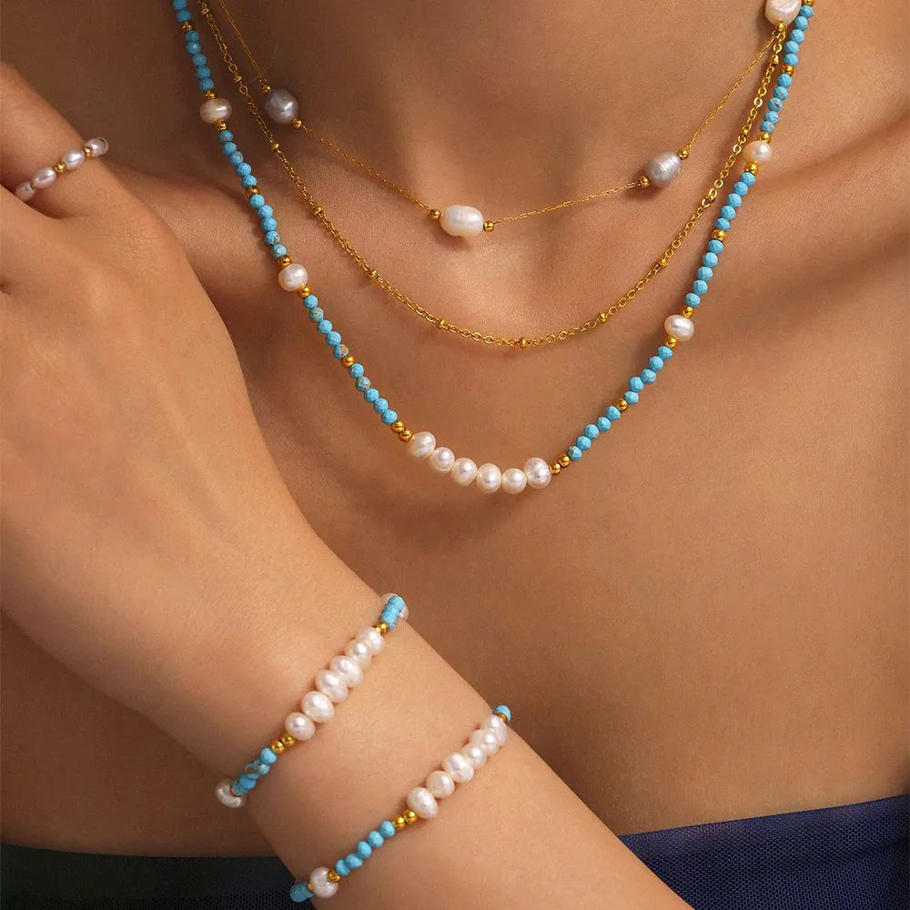 Close-up of the blue turquoise beaded choker necklace featuring a cluster of white freshwater pearls in the center.