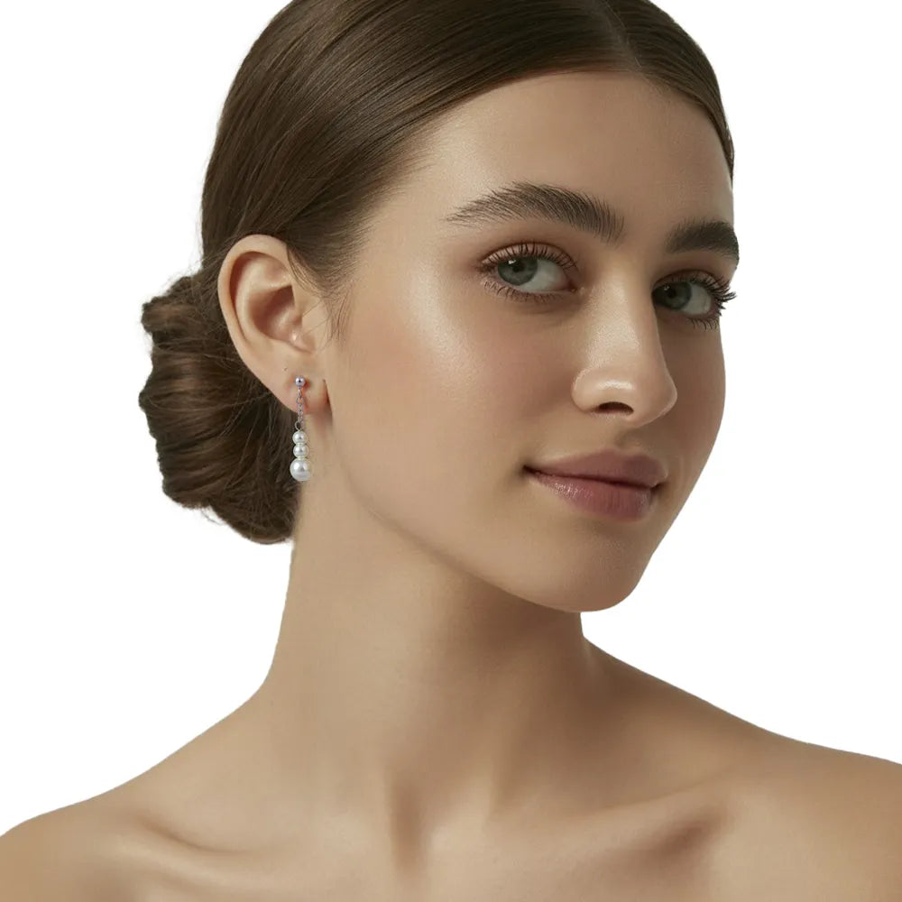 Model wearing elegant linear pearl drop earrings, elongating the neckline.
