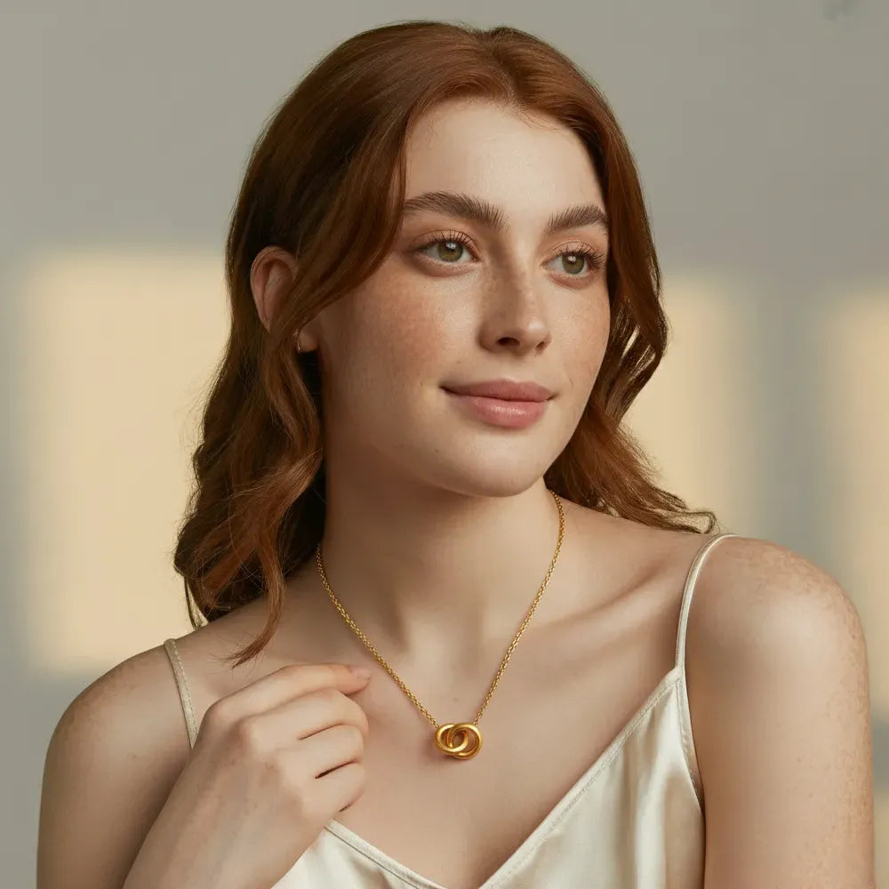 A model wearing the 18k gold plated Thea Interlocking Pendant Necklace to showcase its length and elegant style