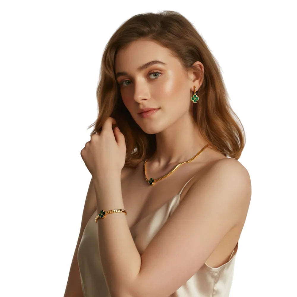 Close-up on a model wearing the gold herringbone necklace, bracelet, and clover earrings.
