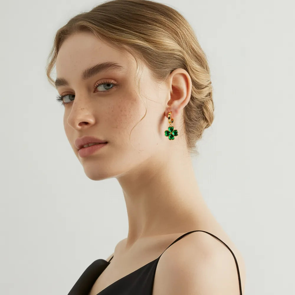 Model wearing the 18k gold Clover Emerald Green Dangle Hoop Earrings.