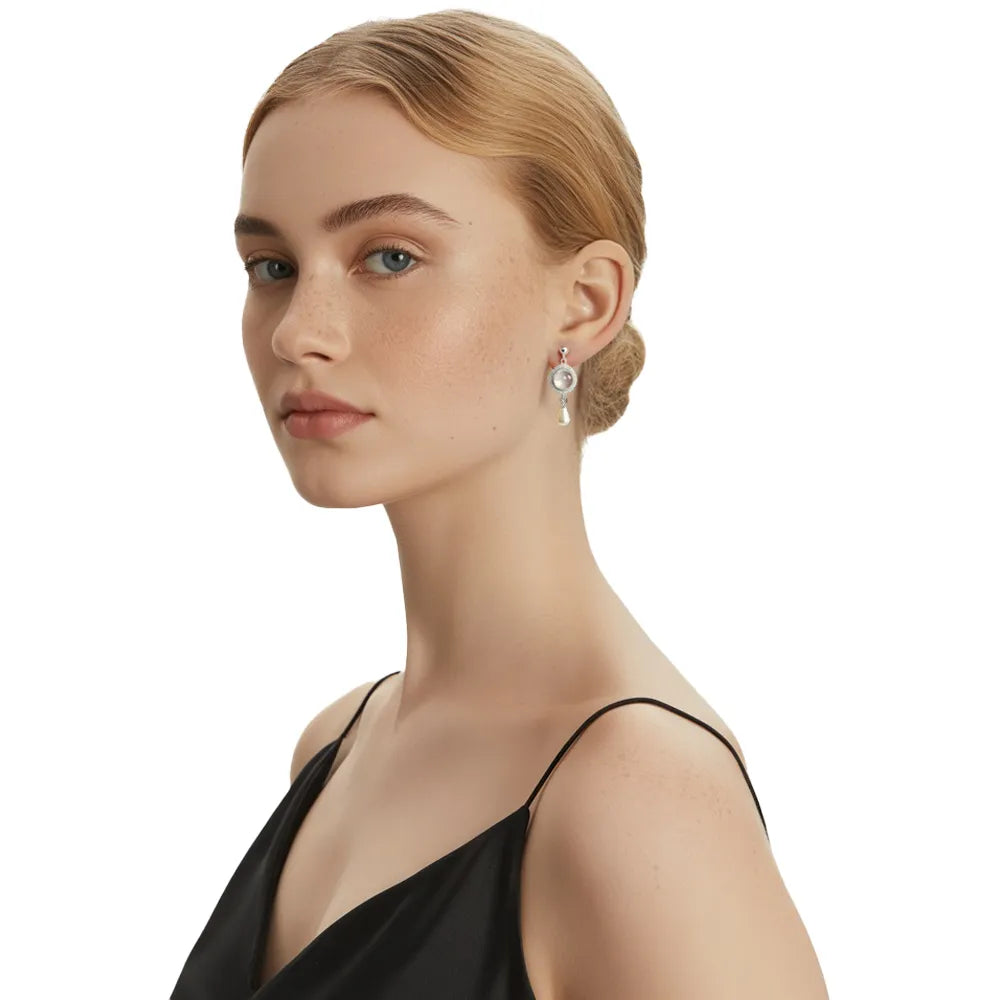 Model wearing elegant vintage pearl drop earrings with a black satin dress