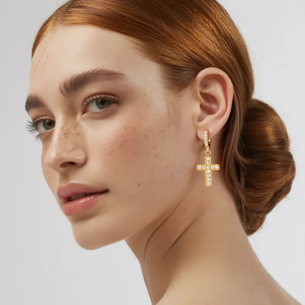Close-up on ear showing the double pavé sparkle of the Grace Cross Huggie Hoops.