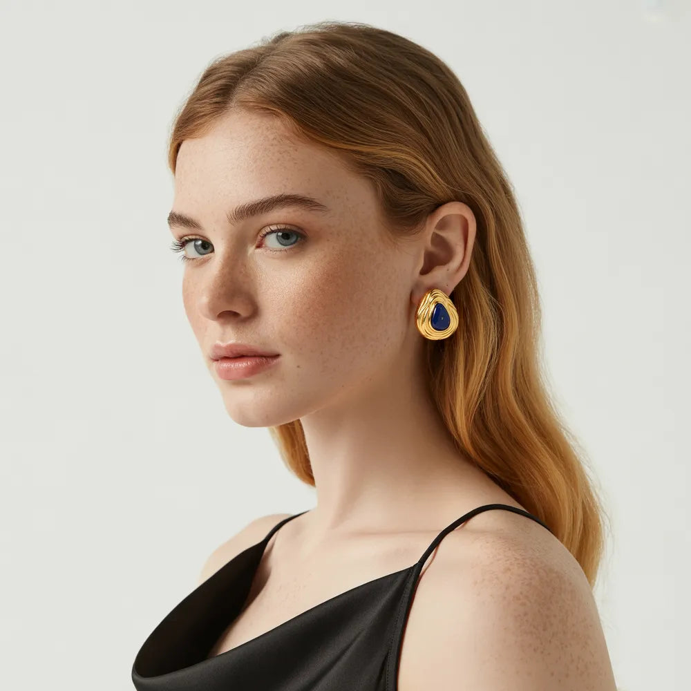 Model wearing the 18k gold Lyra Goldstone Stud Earrings for a statement look.