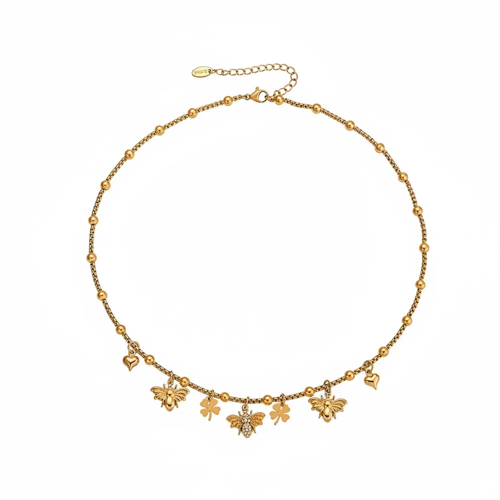 Melia Bee & Clover Charm Necklace in 18k gold with pavé zirconia details on white background.