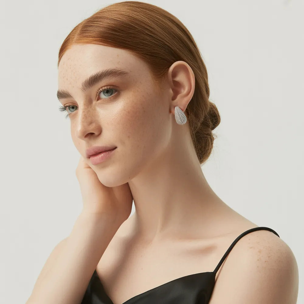 A close-up of the Aura Teardrop Stud Earrings in silver, highlighting the brilliant pavé zirconia details.