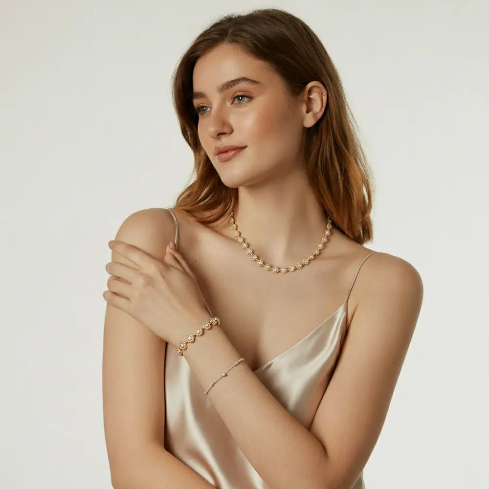 A model showcasing the layered look of the Lucia Zirconia Necklace and Bracelet Set in gold.