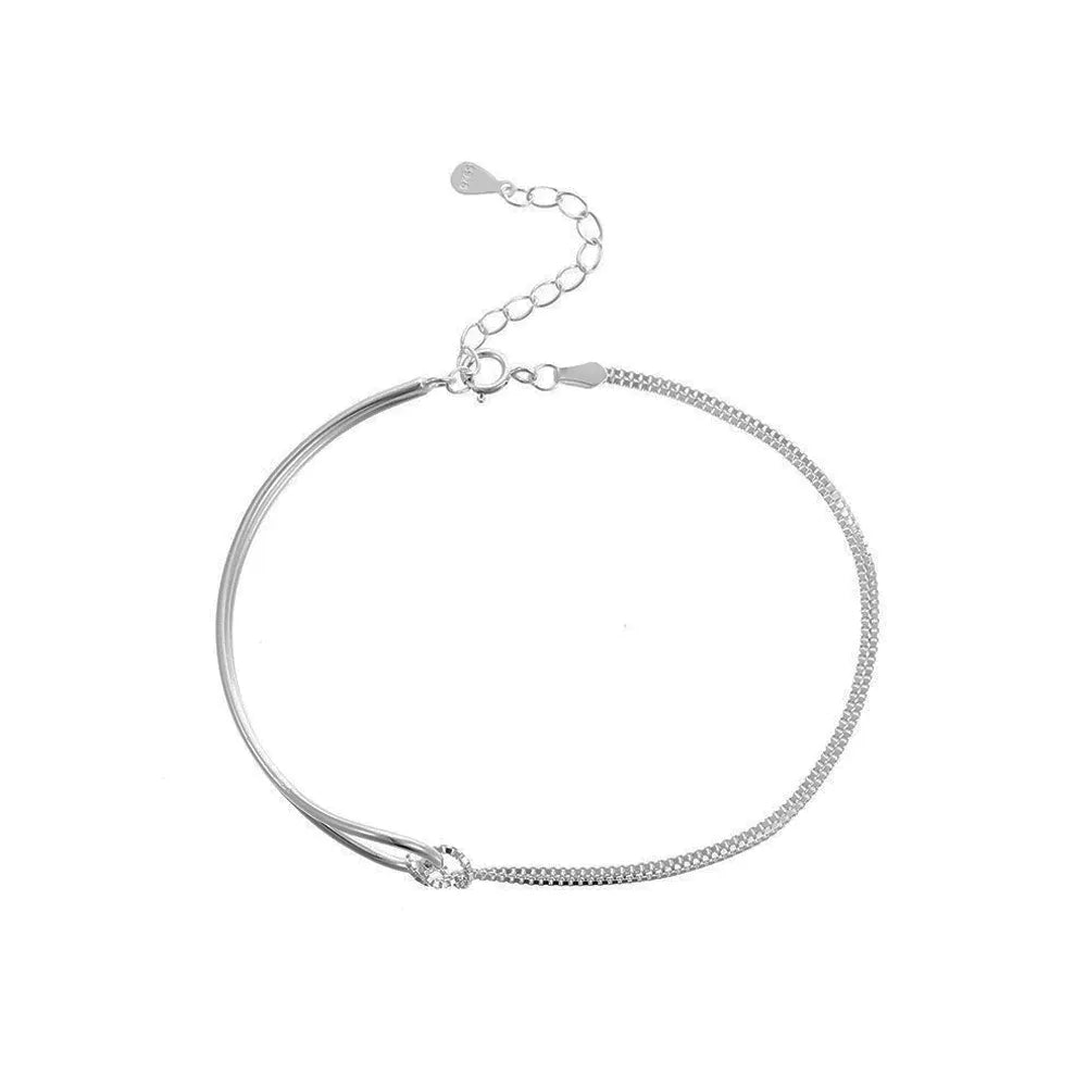 Studio shot of an S925 sterling silver minimalist half-bangle bracelet featuring a crystal-encrusted knot charm, isolated on white.