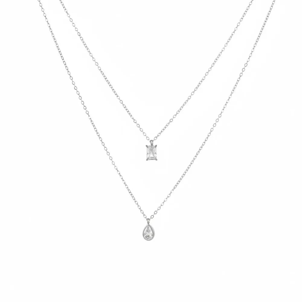 Silver double chain necklace with a geometric rectangle stone and a pear-cut zirconia drop, isolated on white