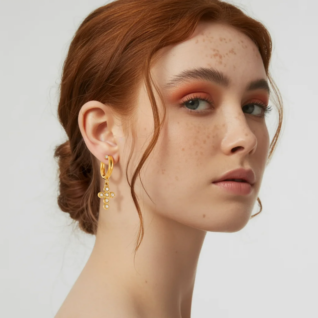 The bezel-set zirconia cross earring dangling from a model&