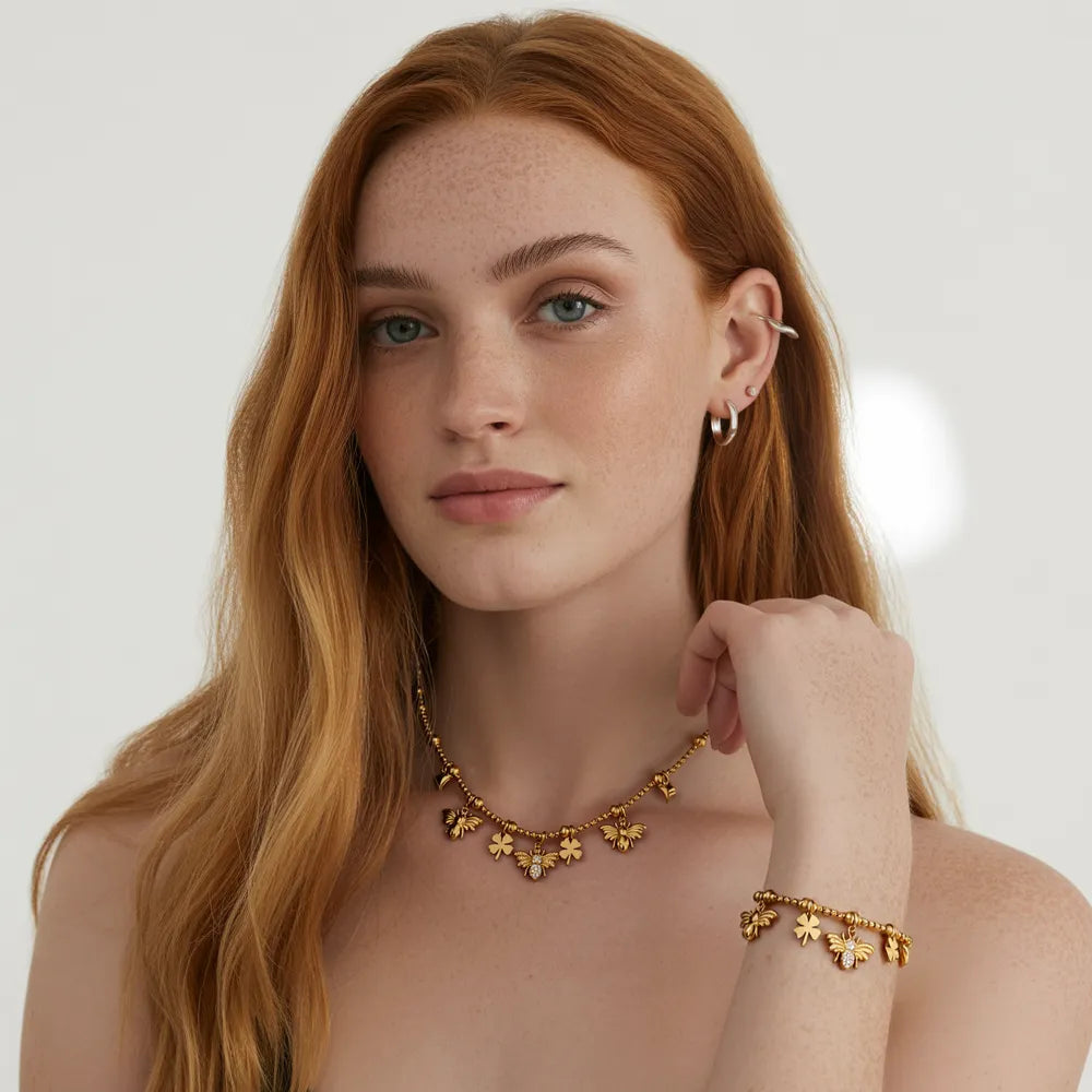 Model wearing the Melia Bee & Clover Charm Necklace and Bracelet set in 18k gold.