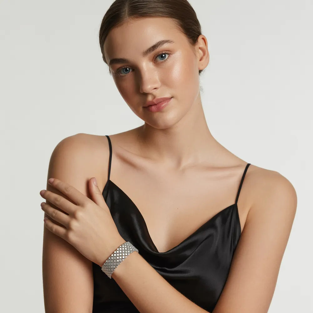 A model's wrist showcasing a stack of sterling silver bracelets, including silver bangles and chains for women, by GlamBodyCandy