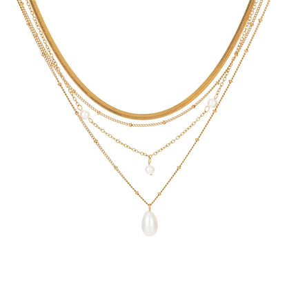 Studio shot of an 18K gold plated multi-layer necklace featuring a herringbone chain and pearl pendants, isolated on white