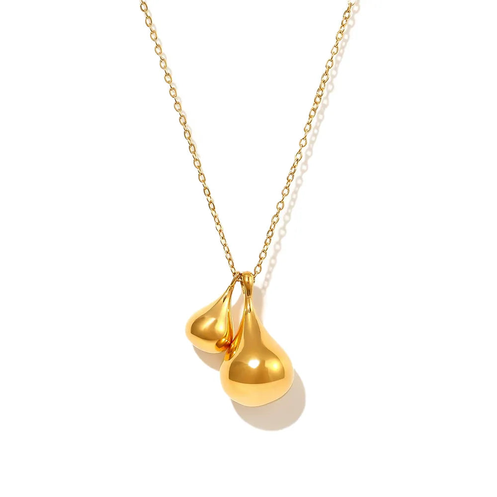 Studio shot of an 18K gold plated long chain necklace featuring a smooth double teardrop pendant, isolated on white