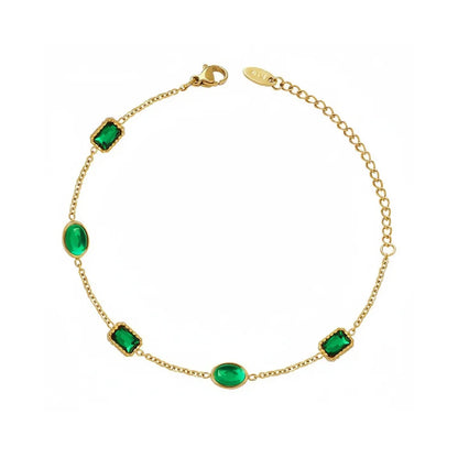 Studio shot of an 18K gold plated bracelet featuring alternating rectangular and oval emerald green zircon stones, isolated on white