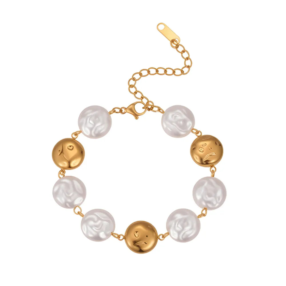 Full view of the 18K gold plated bracelet showing alternating baroque pearls and abstract metal face charms isolated on white