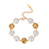 Full view of the 18K gold plated bracelet showing alternating baroque pearls and abstract metal face charms isolated on white