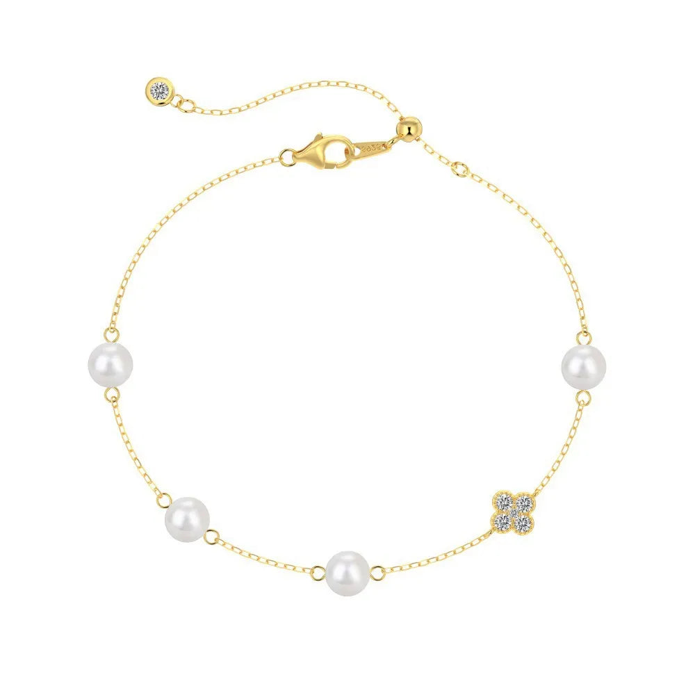 Front view of 18K gold plated S925 silver bracelet with round pearls and a sparkling zircon clover charm.