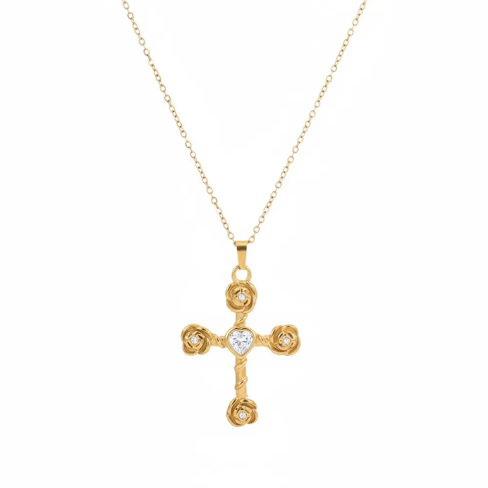Close-up view of the 18K gold plated cross necklace featuring detailed rose blooms at the points and a heart-shaped cubic zirconia center, isolated on white.