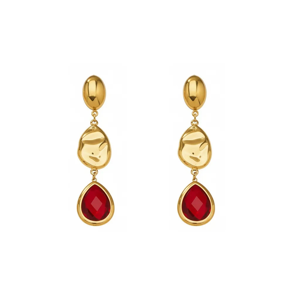 Studio shot of 18K gold plated drop earrings featuring a faceted ruby red glass teardrop stone and textured gold accents, isolated on white.