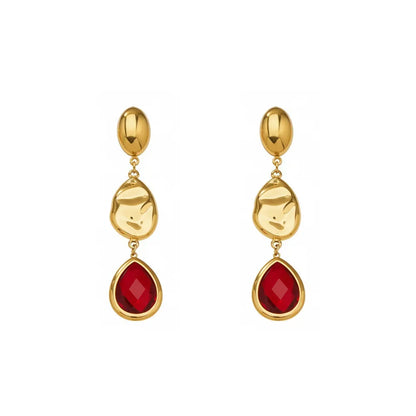 Studio shot of 18K gold plated drop earrings featuring a faceted ruby red glass teardrop stone and textured gold accents, isolated on white.