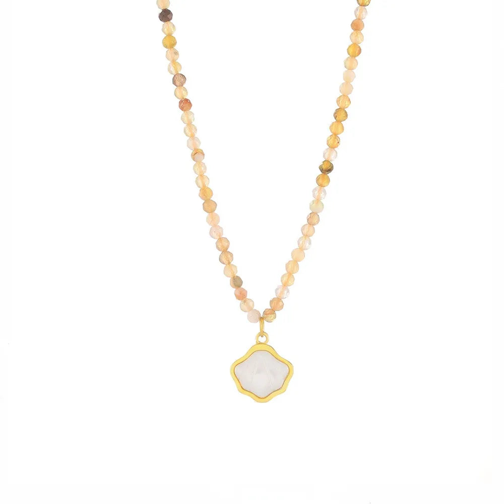 Studio shot of an 18K gold plated necklace featuring a textured scallop shell pendant, isolated on white.