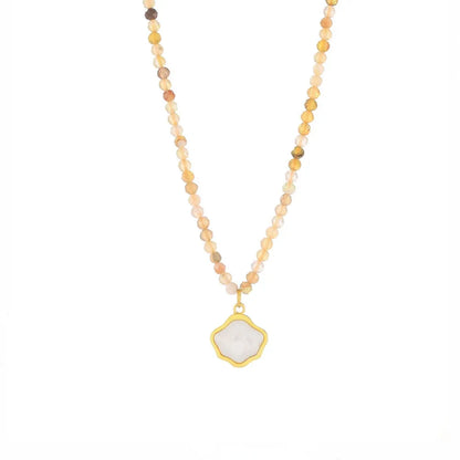 Studio shot of an 18K gold plated necklace featuring a textured scallop shell pendant, isolated on white.