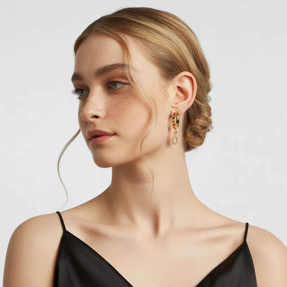 Woman with blonde hair showcasing the elegant dangle of the 18k gold teardrop earrings.