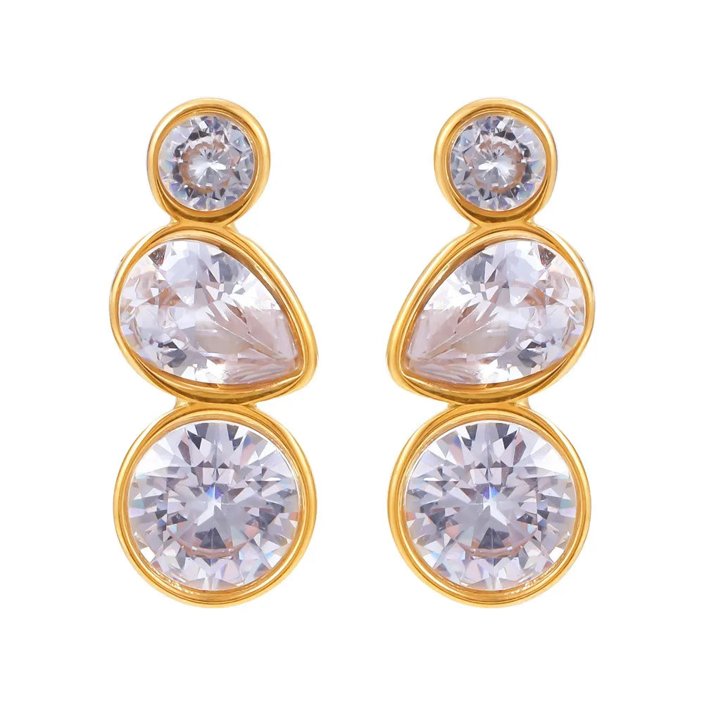 Pair of geometric triple-stone stud earrings (round, pear, round) in 18k gold on white background.