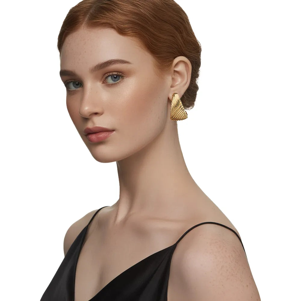 Model wearing chunky gold ribbed C-hoop earrings, showing the side profile fit and size on the ear.