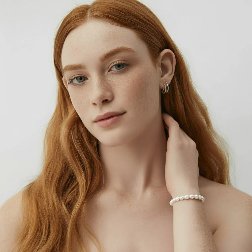 A model wearing the elegant Perla Pearl Station Bracelet, showcasing its classic and versatile style.