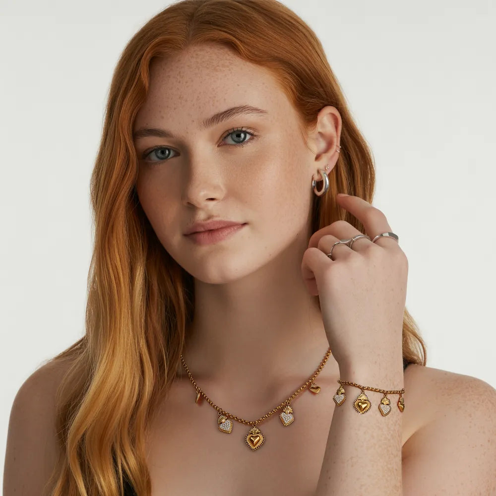 Model wearing the Corazón Sacred Heart Necklace and Bracelet set in 18k gold.