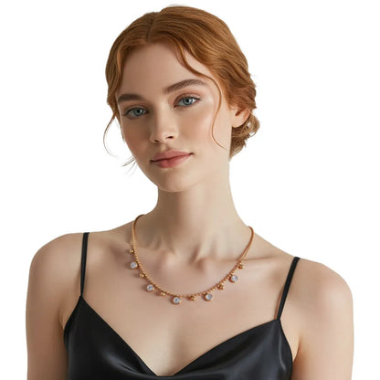 Model wearing a dainty gold drop necklace with white zirconia stones, showing the elegant collarbone length fit