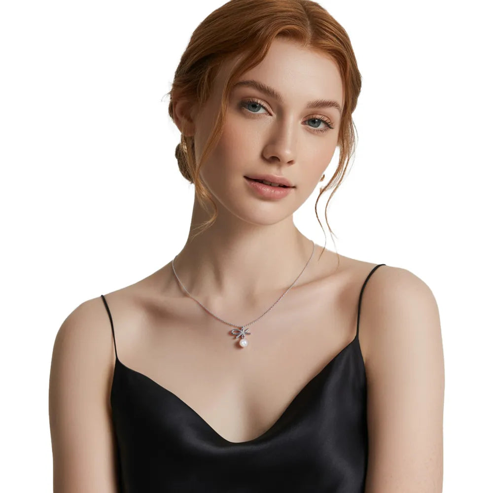 Model wearing a dainty S999 fine silver bow necklace with a pearl charm.