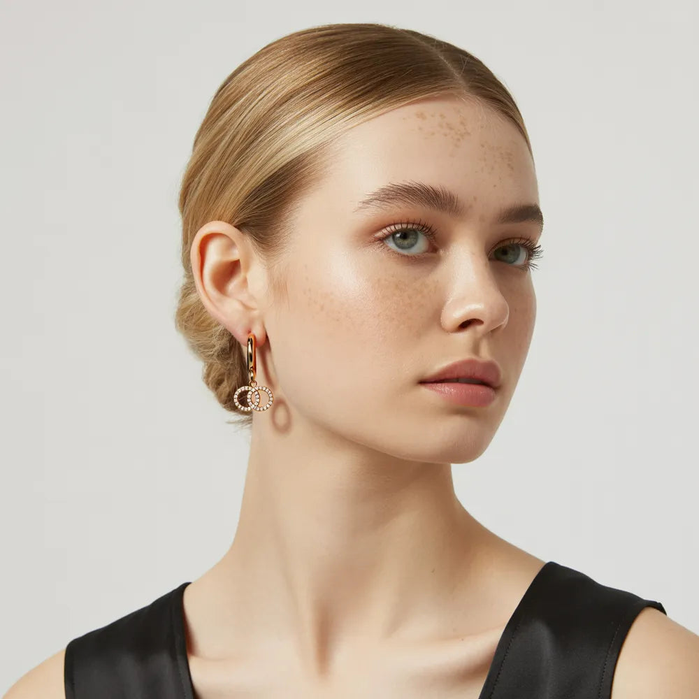 Model with blonde hair wearing the Elysia Interlocking Hoop Earrings, showcasing their elegant dangle.