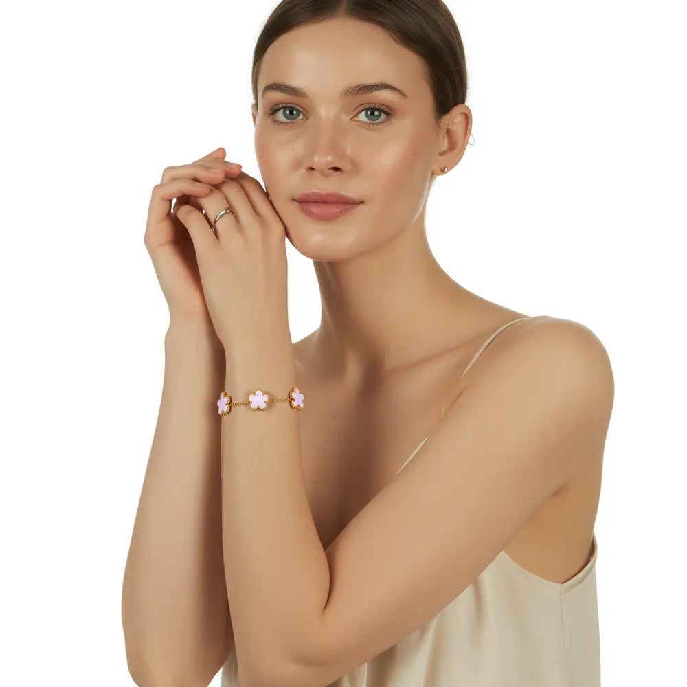 A model showcasing her full outfit, featuring the 18k gold plated Fleur Bloom Bracelet with a white seashell stone