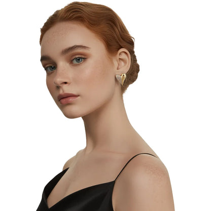 Side profile view of a model styling the chunky 18K gold half-pave heart studs for a modern, elegant look.