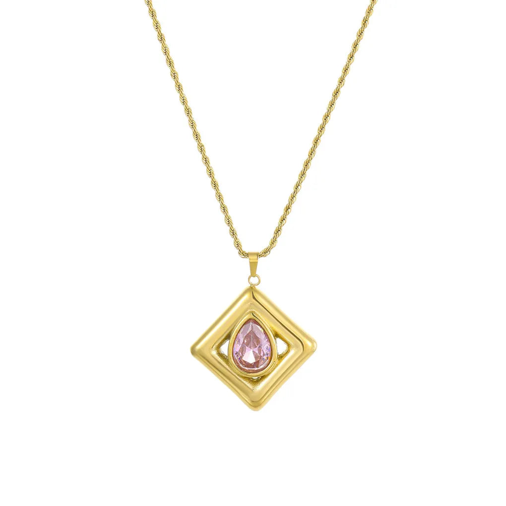 Close-up of a gold square frame pendant necklace with a sparkling pink pear-cut stone, shown on a white background