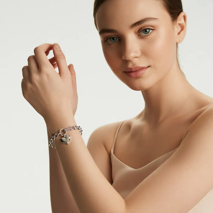 Woman with red hair showcasing the chic silver-tone bracelet with a heart charm.