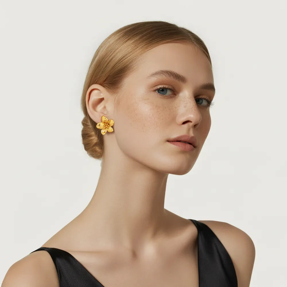 Model showcasing the large 18k gold Helia Statement Flower Studs for a bold look.