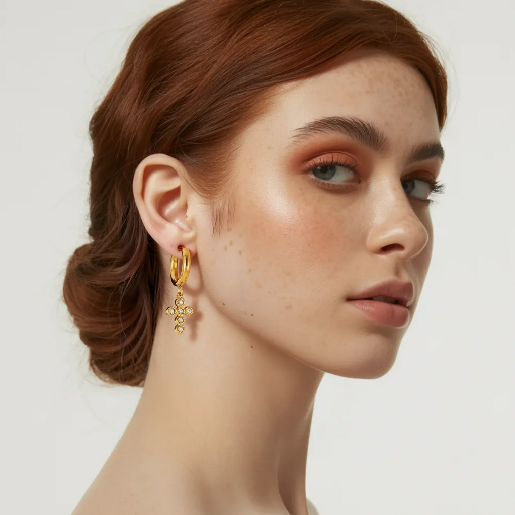 A woman showcasing the elegant look of the Hope Bezel-Set Cross Hoop Earrings