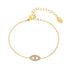 18k gold dainty chain bracelet with a sparkling pavé evil eye charm on a white background