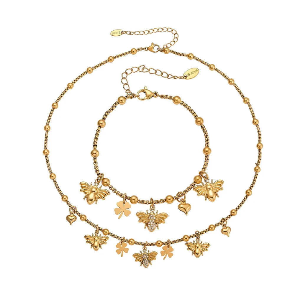 Overview of the Melia Bee & Clover Charm Necklace and Bracelet set in 18k gold.