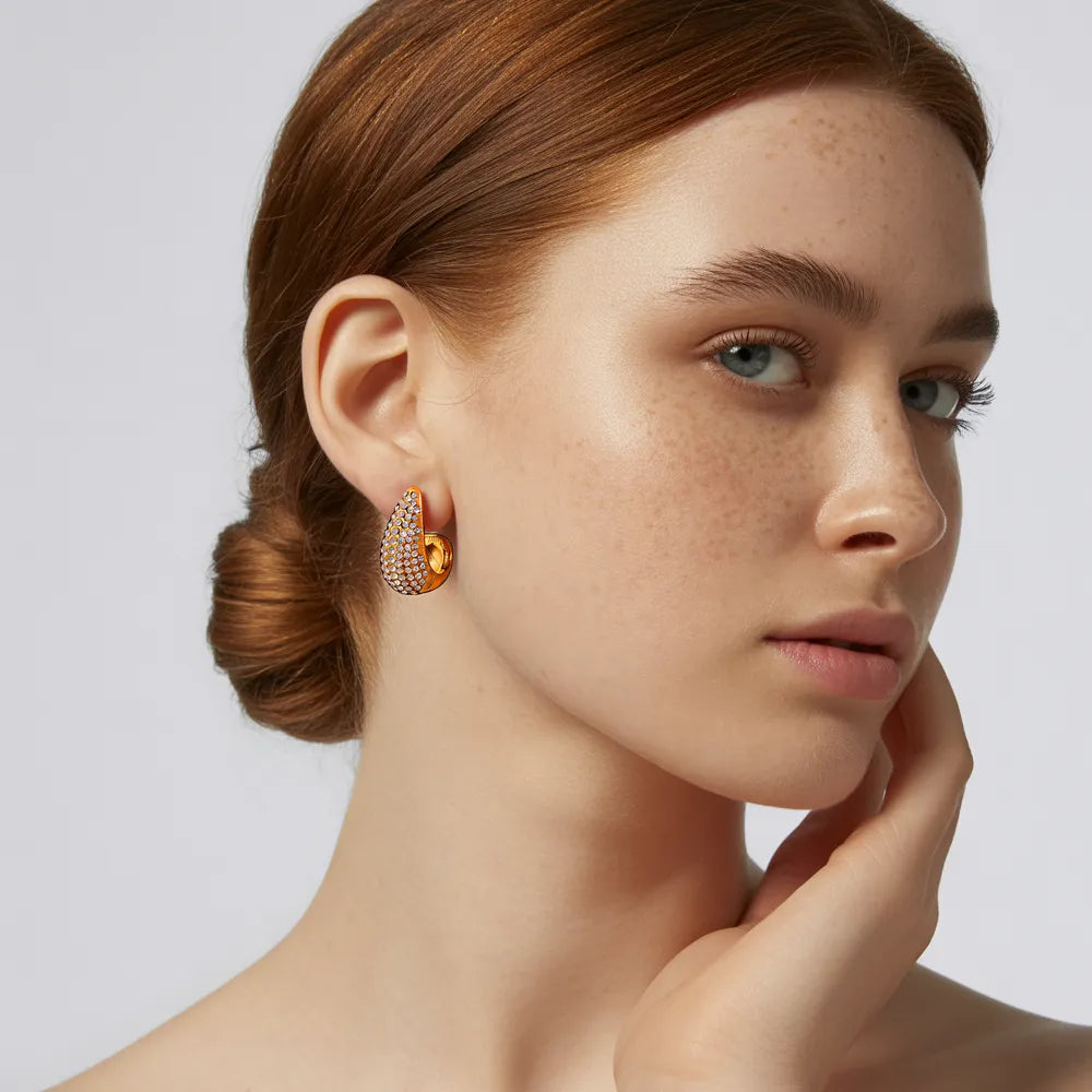 A model wearing the sparkling 18k gold plated Aura Teardrop Stud Earrings to showcase their statement size.